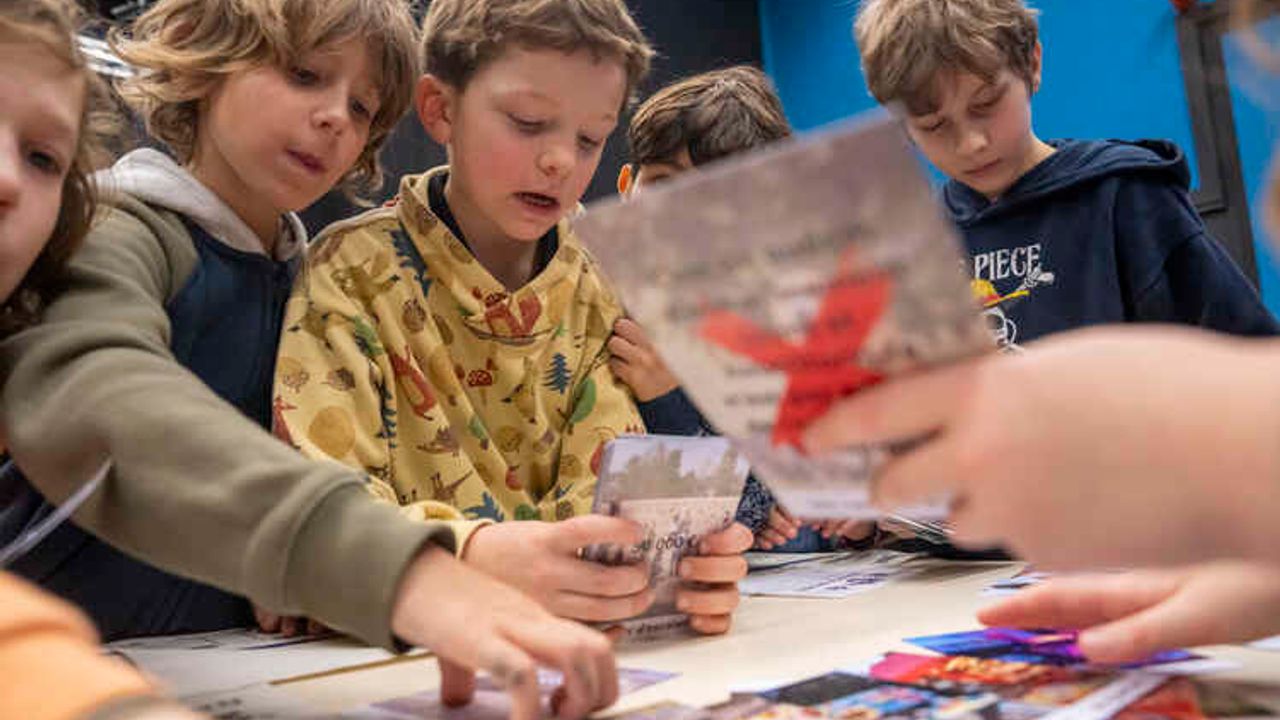 Des enfants sont autour d'une table, ils échangent sur leurs projets. 