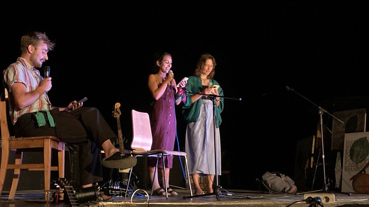 People on stage at night performing for the open mic