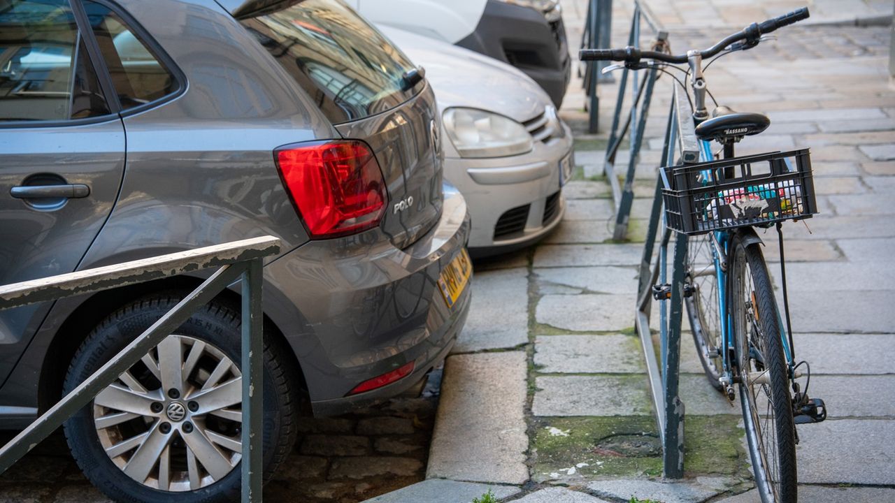 Véhicules en stationnement dans une rue rennaise.