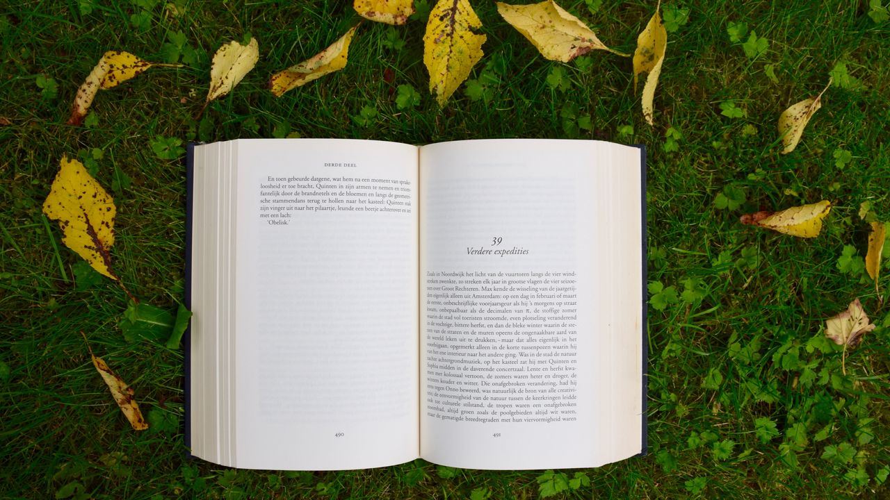 opened book on grass during daytime