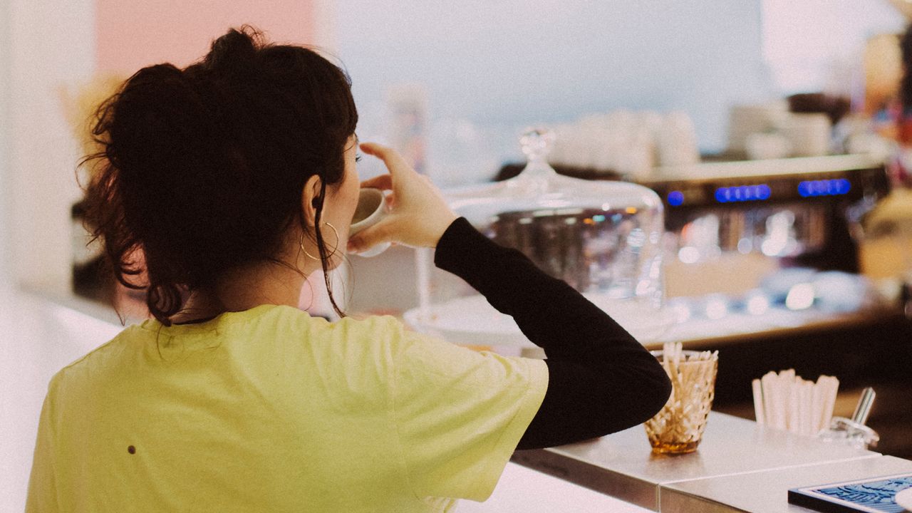 Une cliente bois un verre d'eau, disponible en libre service au bar