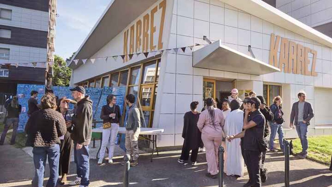Des jeunes et animateurs des structures partenaires discutent devant le bâtiment du Karrez le soir de son inauguration.