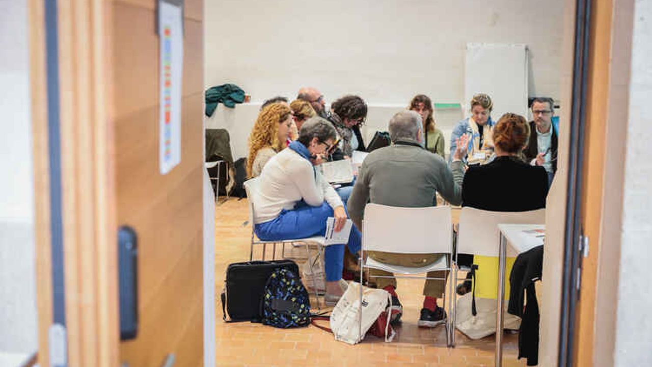 Des personnes en réunion autour d’une table dans une salle.