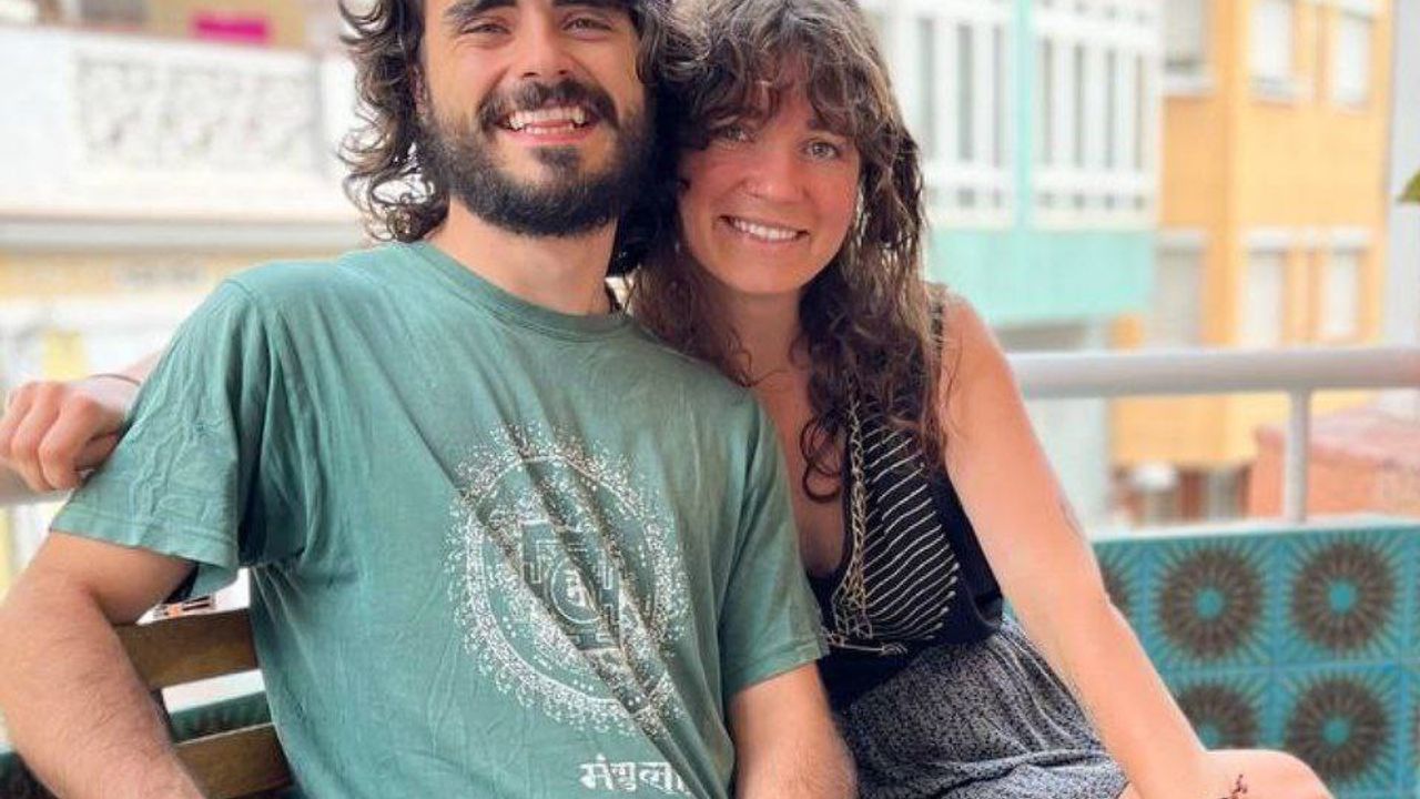 JP and Inea posing together, sitting outside on a balcony.