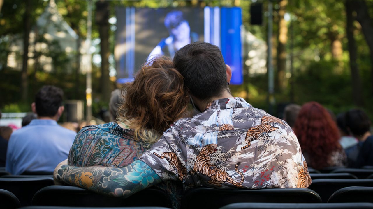 Couple en sortie vus de dos regardant un cinéma en plein air