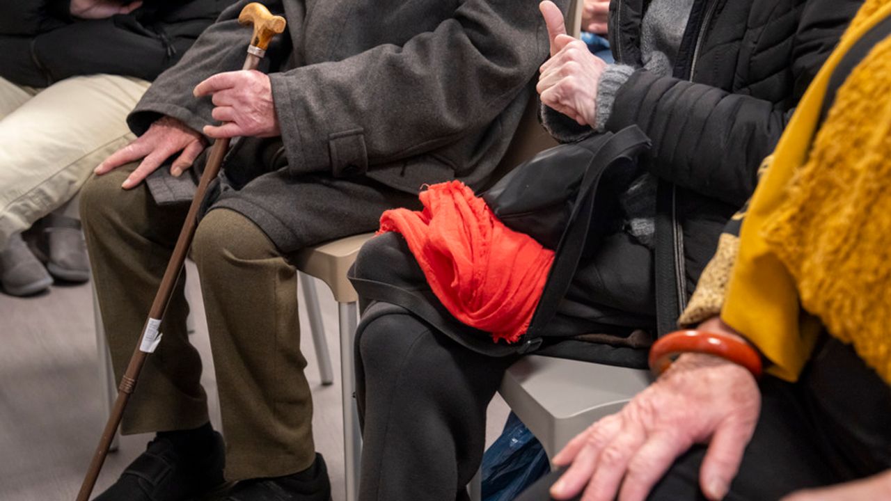 Vue des mains de personnes âgées assises côte à côte.