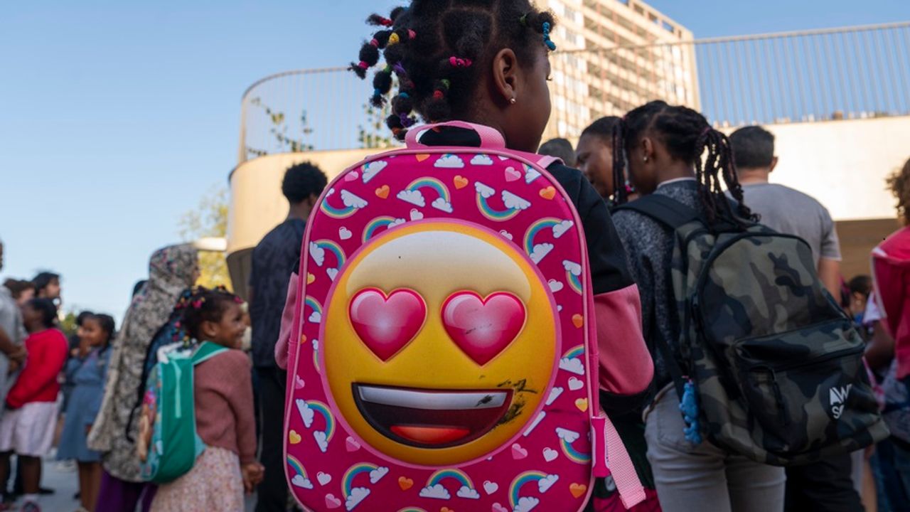 Une fillette avec son cartable attend la rentrée des classes devant l’école Toni-Morrison.