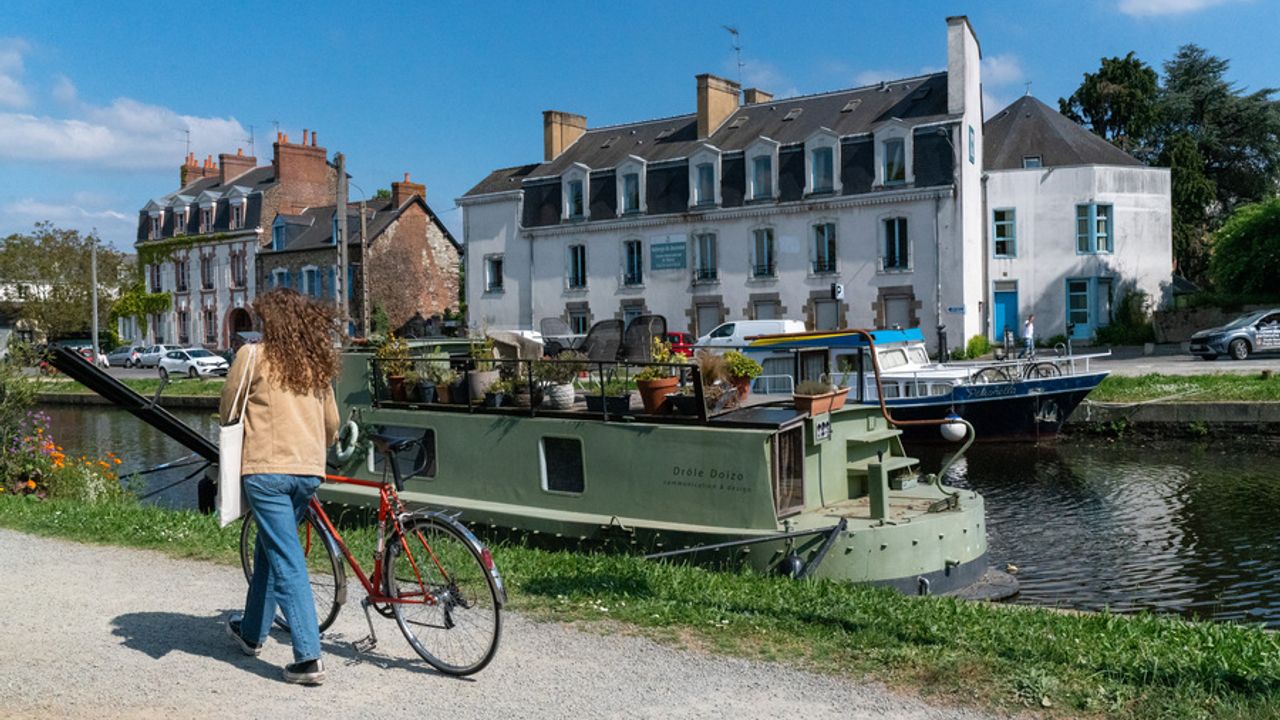 canal saint martin, une femme se promène avec son vélo