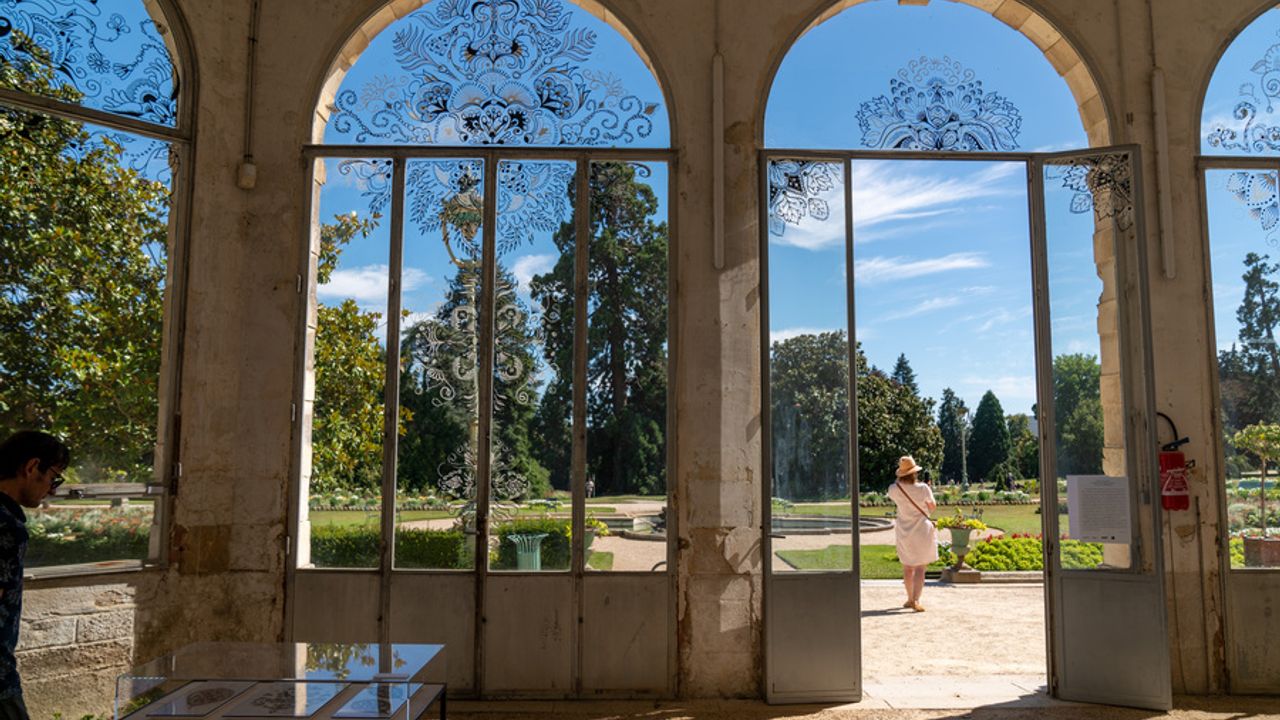 Vue de l’intérieur de l’Orangerie du Thabor. Ses immenses fenêtres donnant sur le jardin un jour d’été.