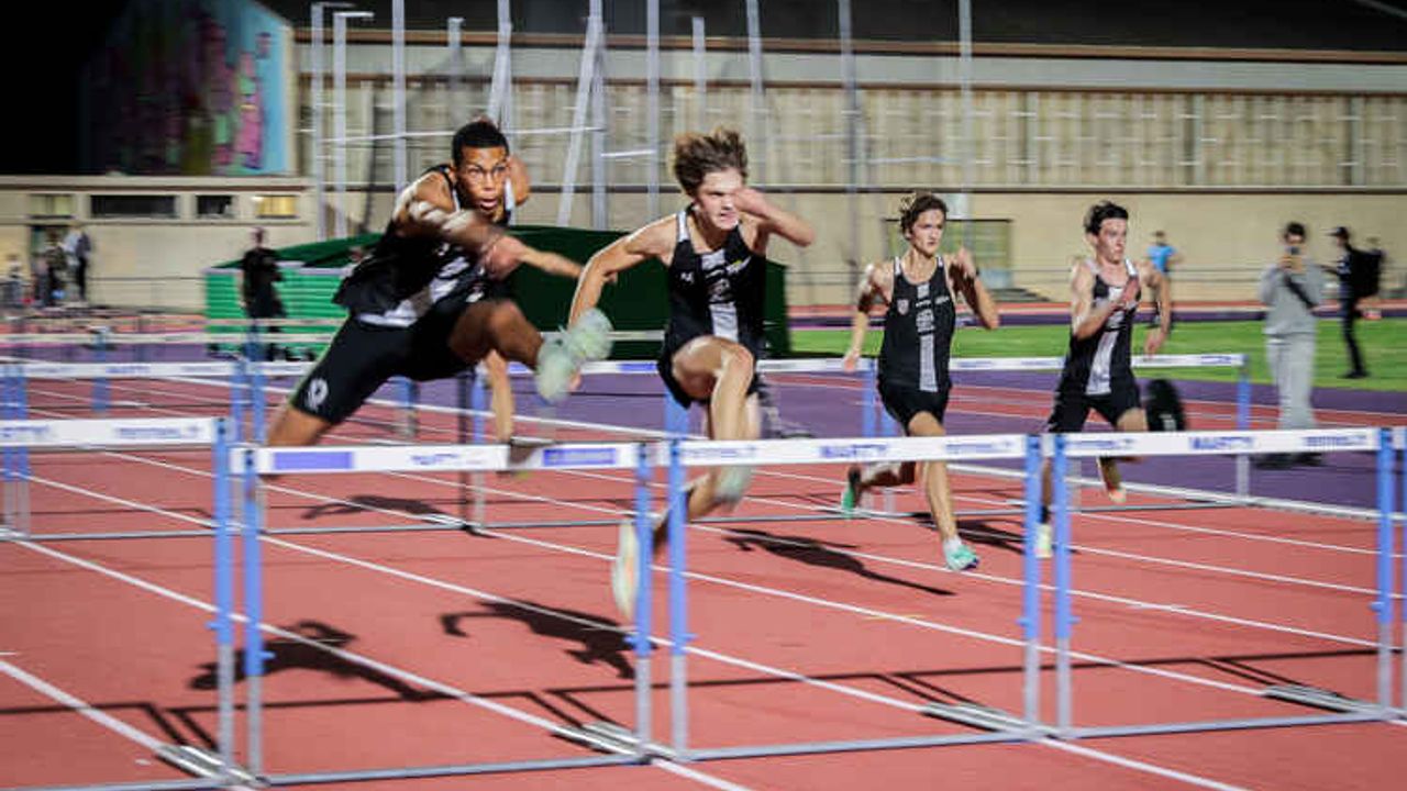 Des athlètes sur la piste sautent à la haie