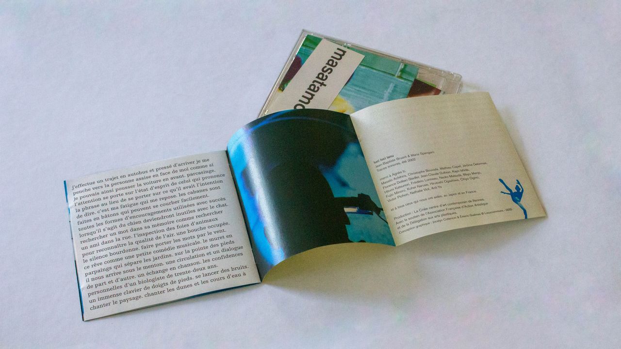 livret sorti du boitier et ouvert. Une page se déplie ce qui donne document en trois volets, sur lesquels on voit, de gauche à droite, un texte, une photo et les crédits de l'édition.