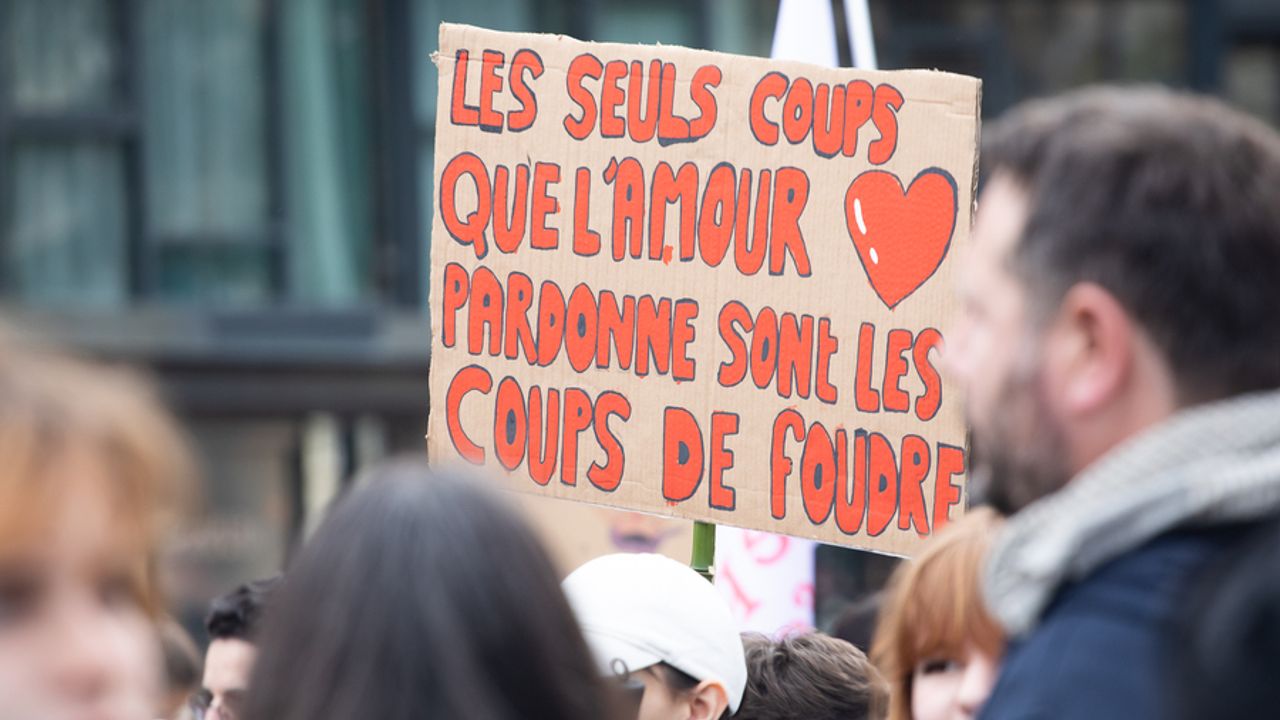 Personnes dans la rue avec pancartes.