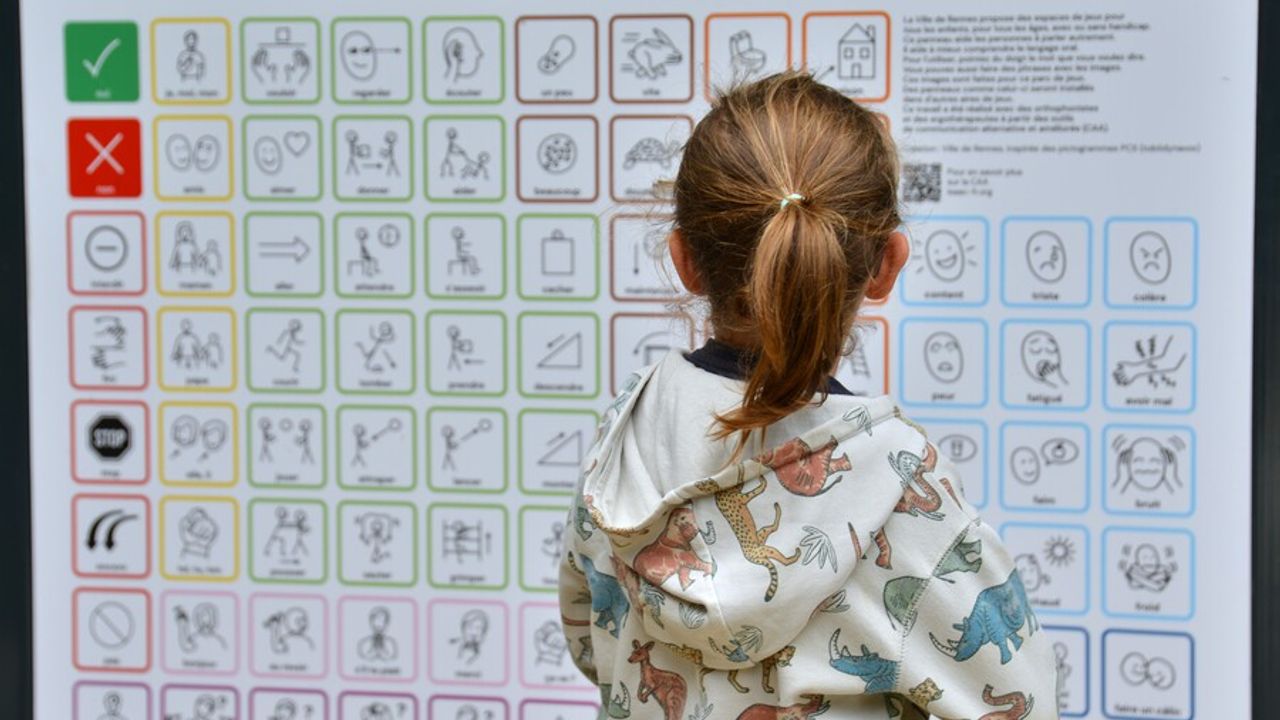 une enfant devant un tableau de communication non verbale
