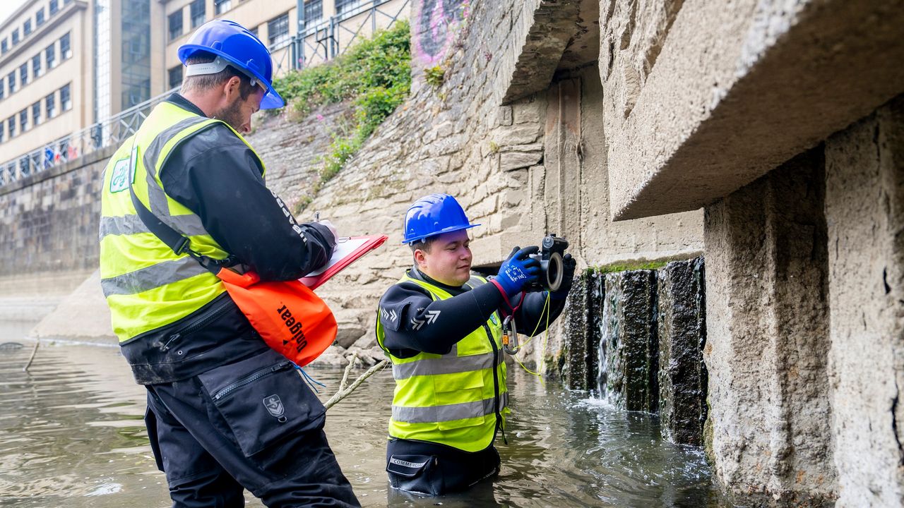 Deux hommes inspectent un ouvrage subaquatique sur la Vilaine à Rennes.