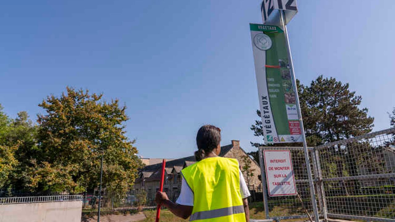 une agente de déchèterie devant un apport de végétaux