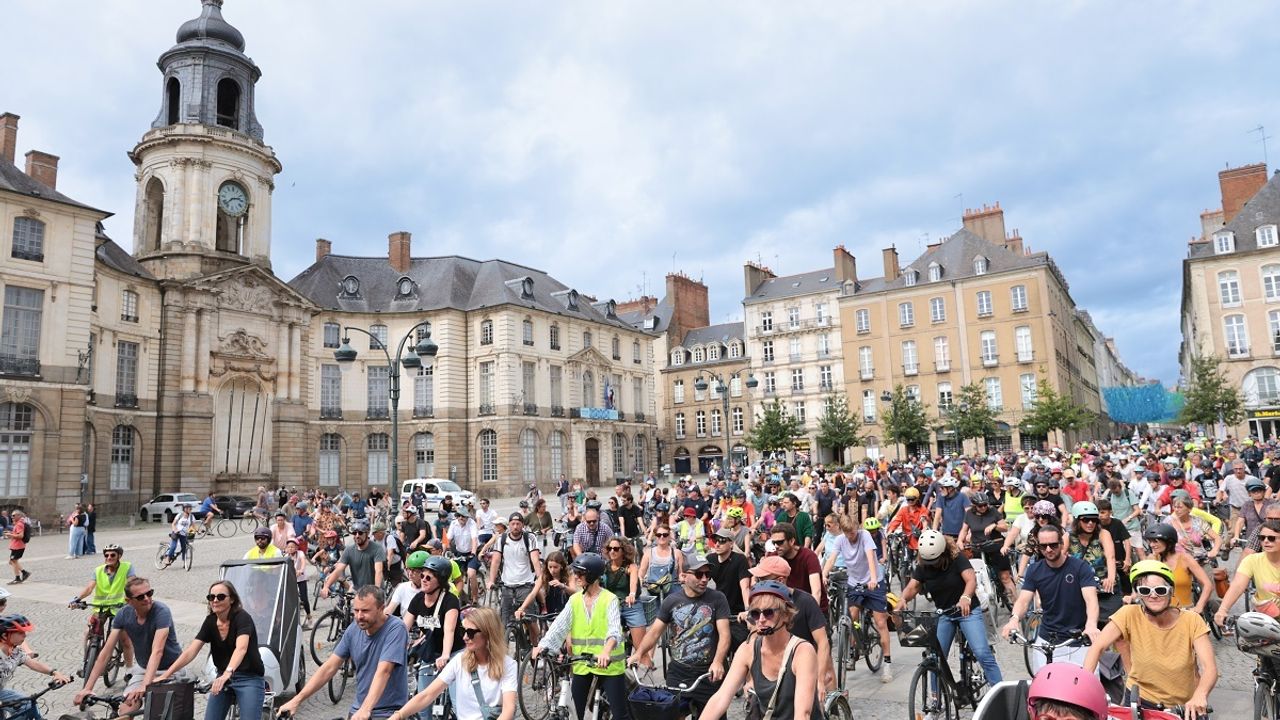 Tour de Reine à vélo, un groupe de cyclistes, nombreux, stationne devant la Mairie.