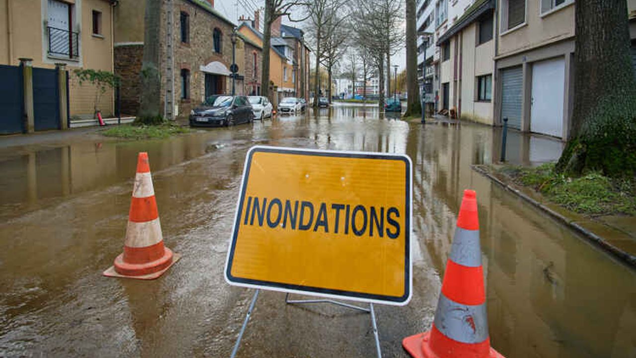 Un panneau de signalisation indiquant des inondations à l'entrée d'une route barrée à la circulation.