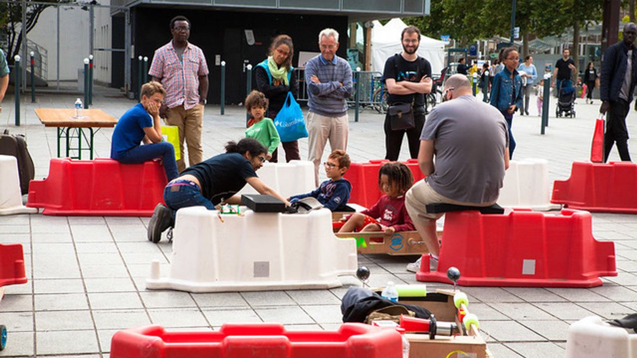 installations éphémères avec des plots rouges et blancs et des personnes participant à un atelier de fabrication