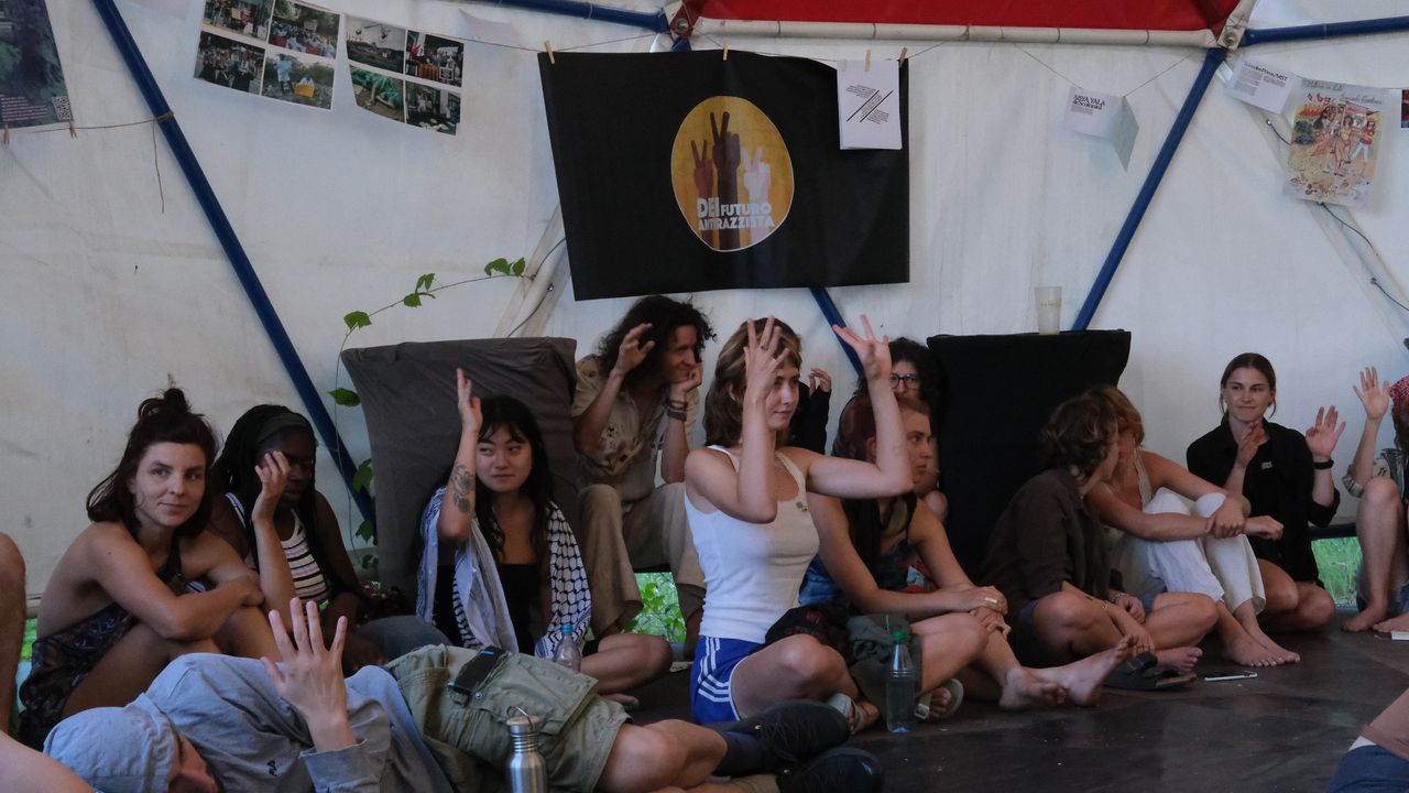 Audience sitting on the floor shaking hands in agreement