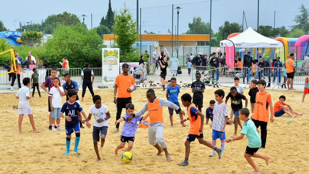 Des jeunes enfants qui jouent au ballon sur la plage Berry