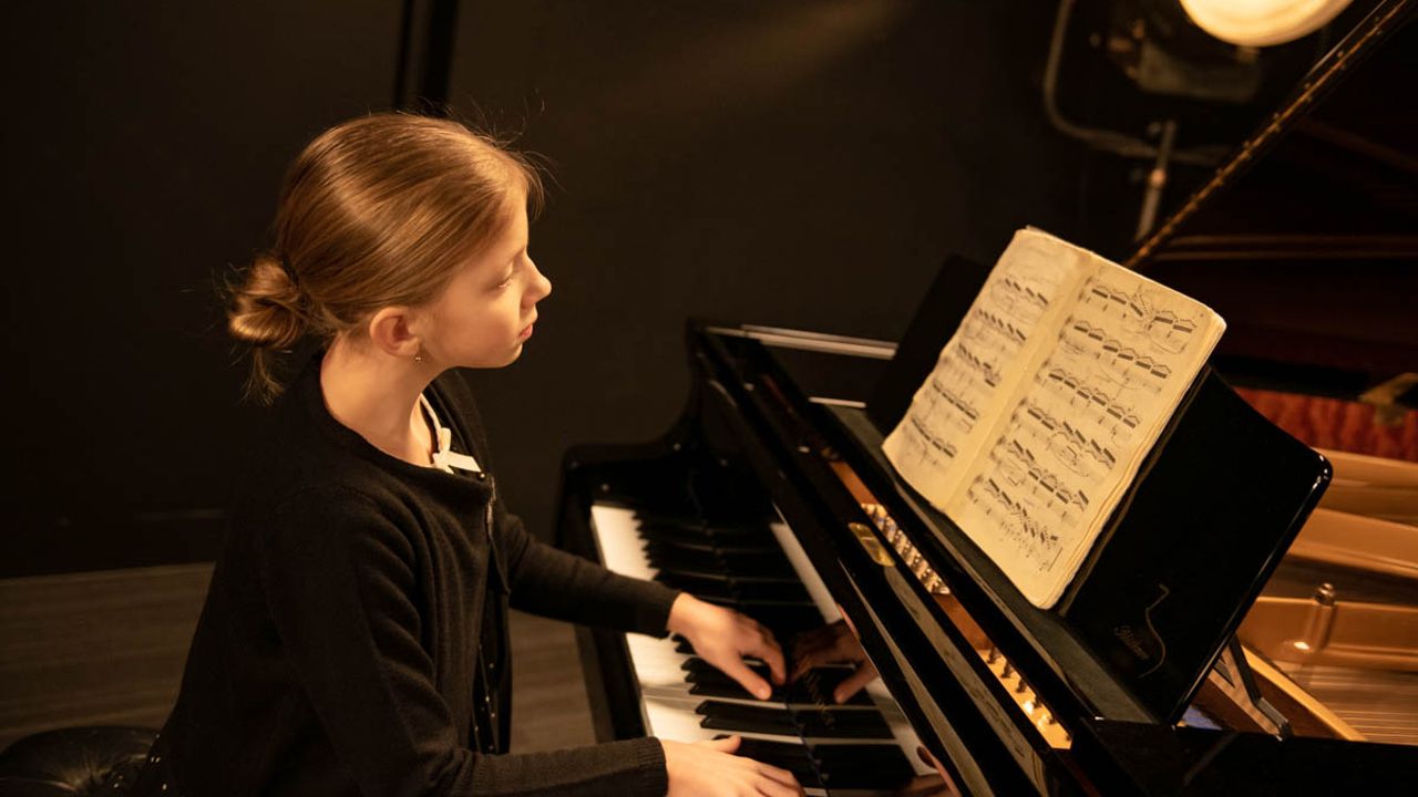 Nora Kostenko, jeune pinaiste ukrainienne de 13 ans, assise à son piano