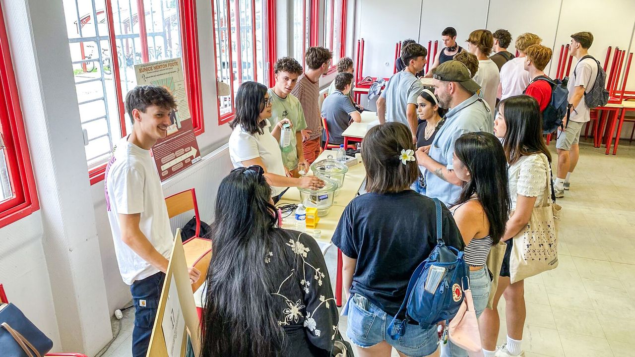 Etudiants présentant leur projet sous forme d'infographie et de démo sur table.