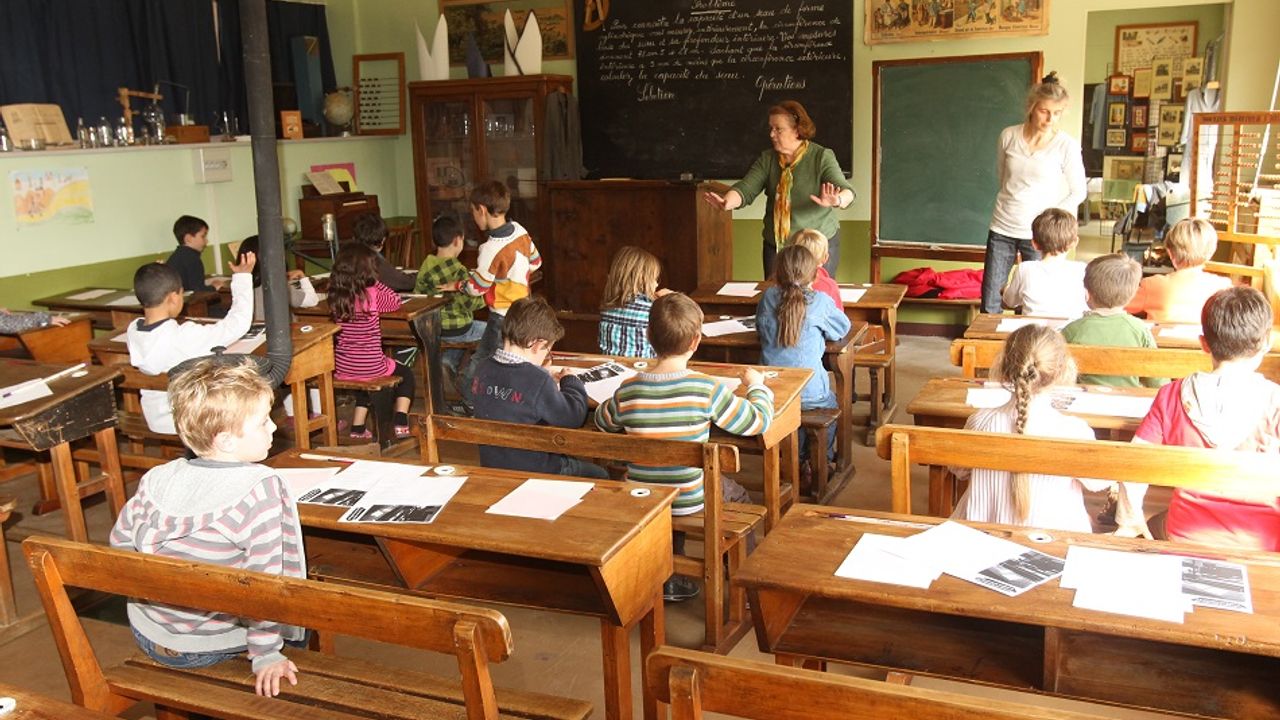 Des élèves assis dans une classe face à une professeure.