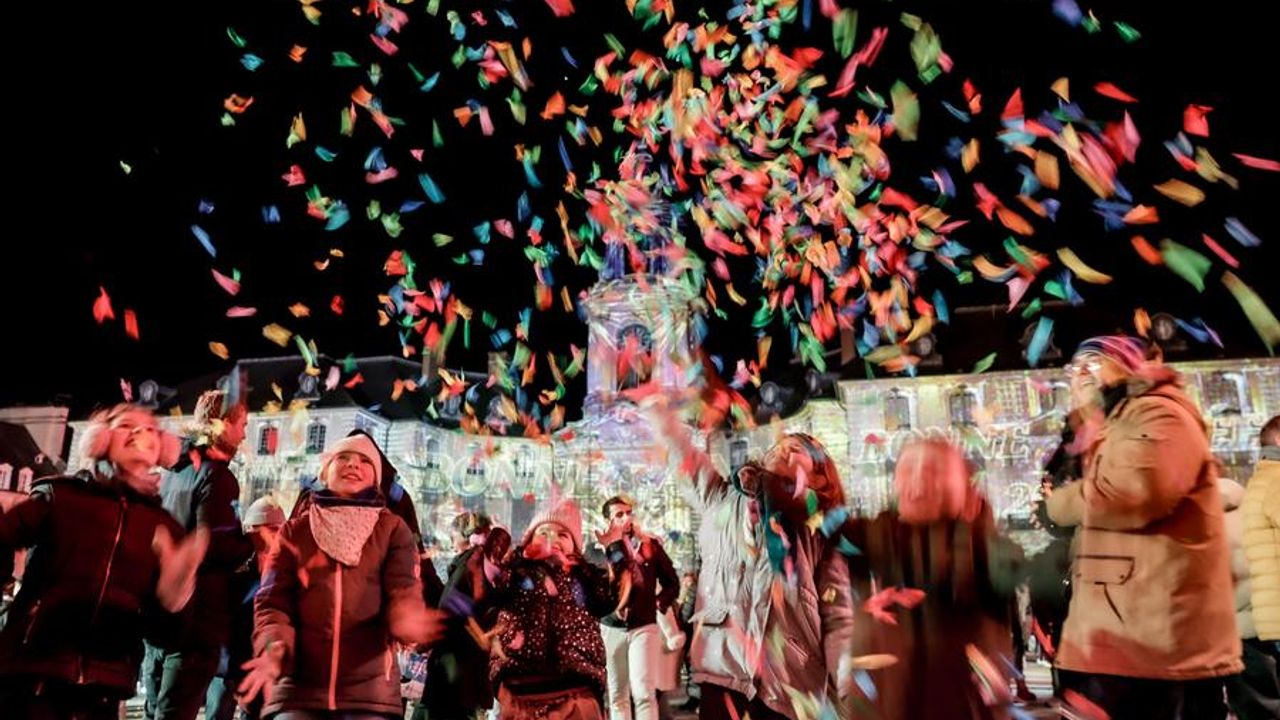 Un public en fête avec des cotillons place la mairie 