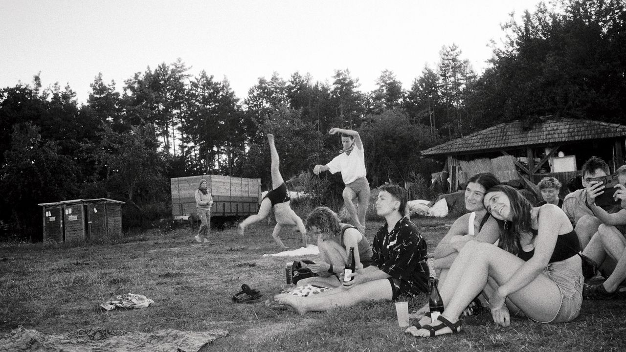 people sitting in the grass watching a performance and two people dancing