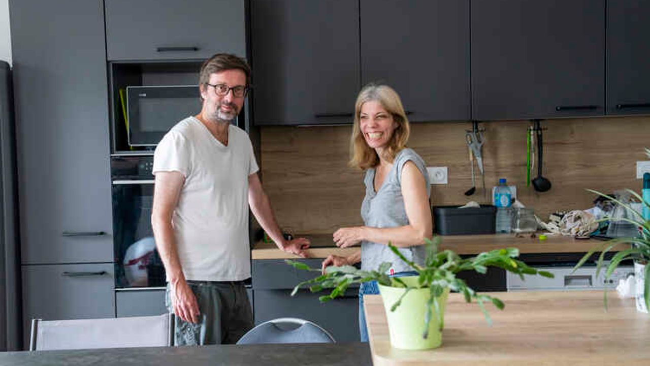 Un homme et une femme dans la cuisine de leur appartement.