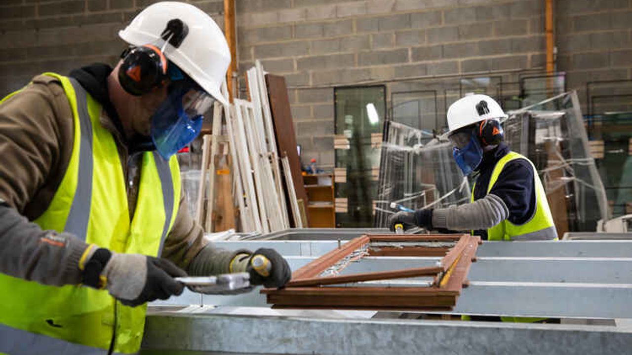 Des menuisiers restaurent une fenêtre dans un atelier