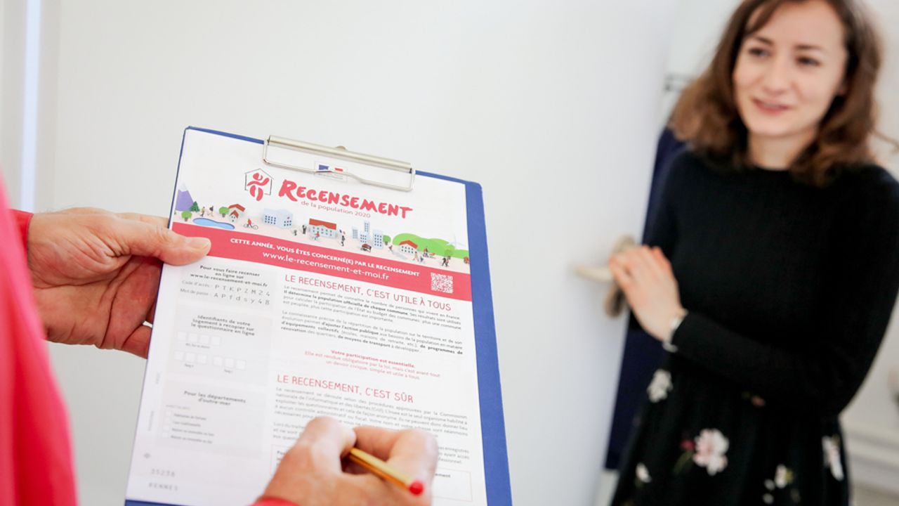 Une personne avec une fiche de recensement à la main