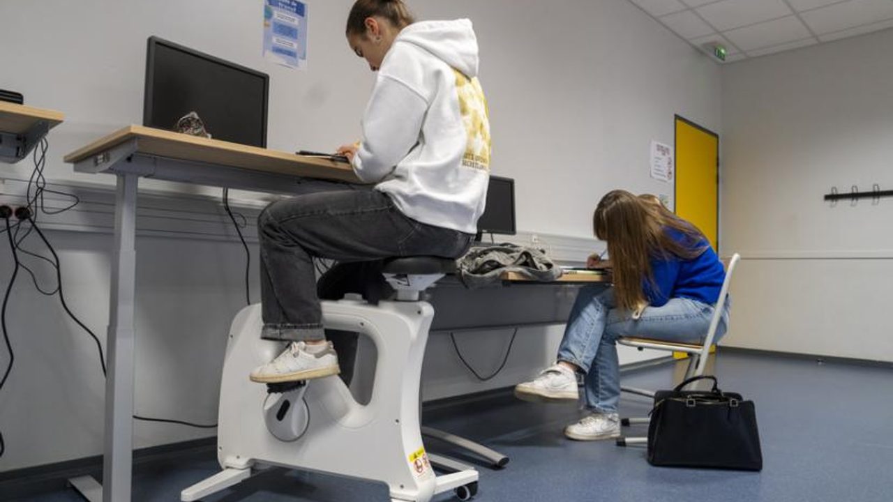 Une lycéenne est assise sur "un vélo-bureau" pour étudier en classe tout en pratiquant une activité sportive.