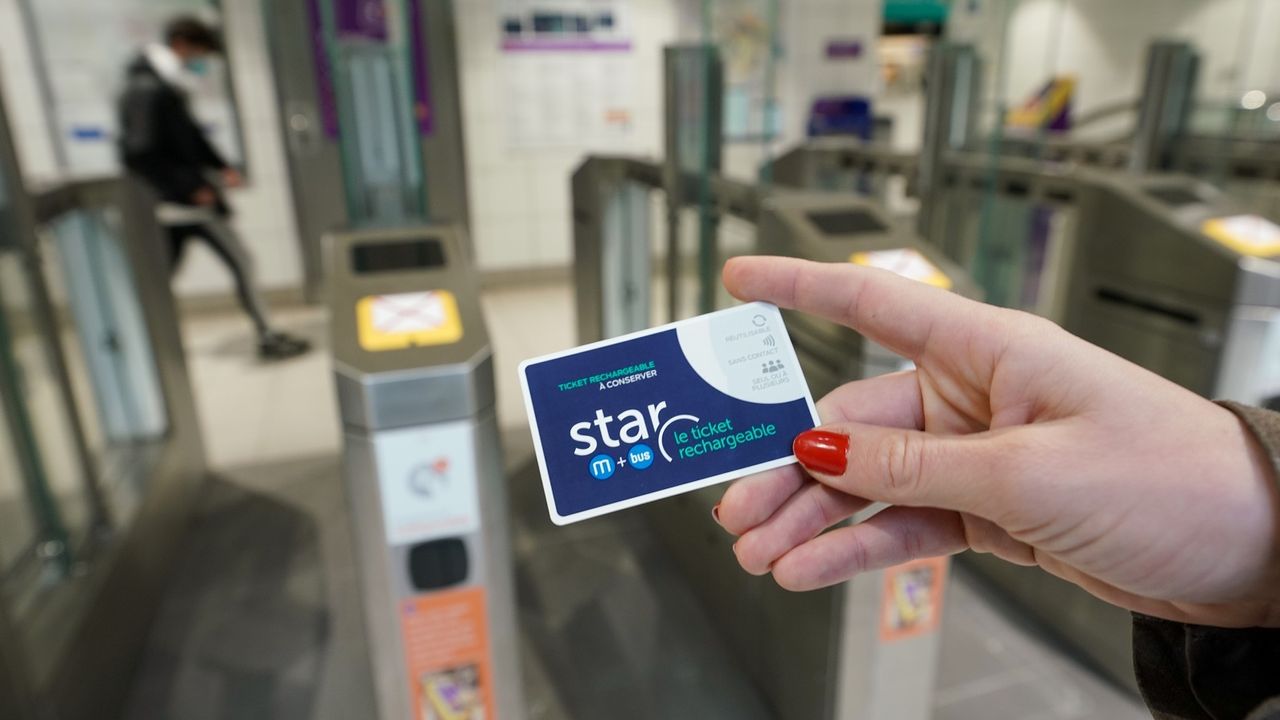 Photo d’un titre de transport au premier plan, en arrière-plan, les portillons de la ligne a du métro.