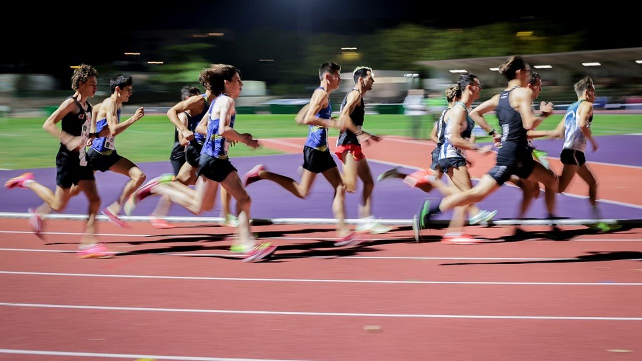 Des sportifs en pleine course sur une piste d’athlétisme.
