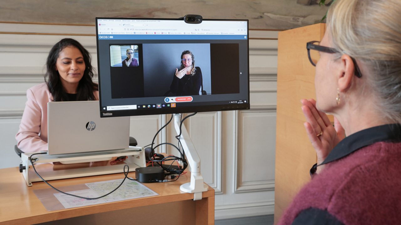 Deux personnes échangent grâce à un équipement informatique adapté.
