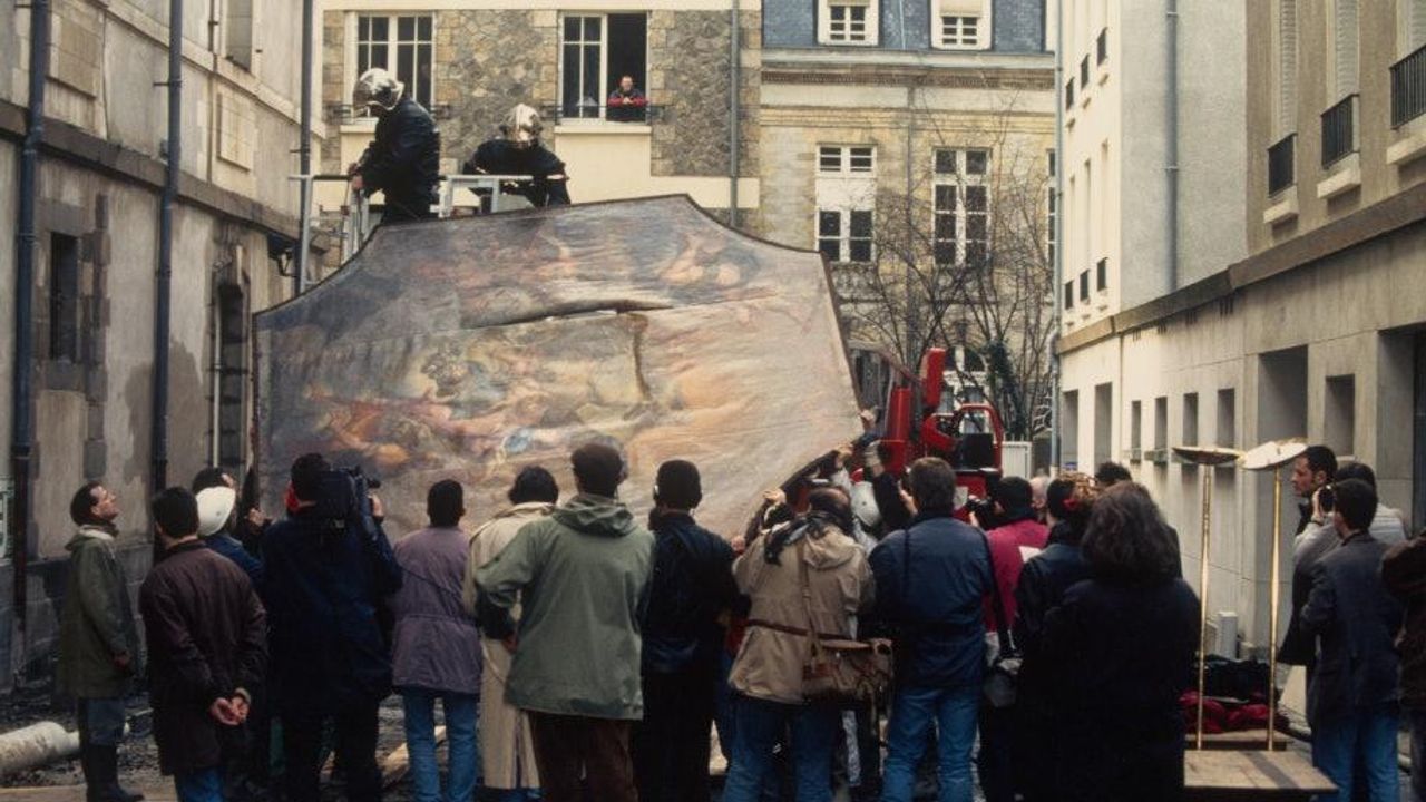 Les pompiers évacuent les objets qui peuvent sauvés pendant que des gens observent.