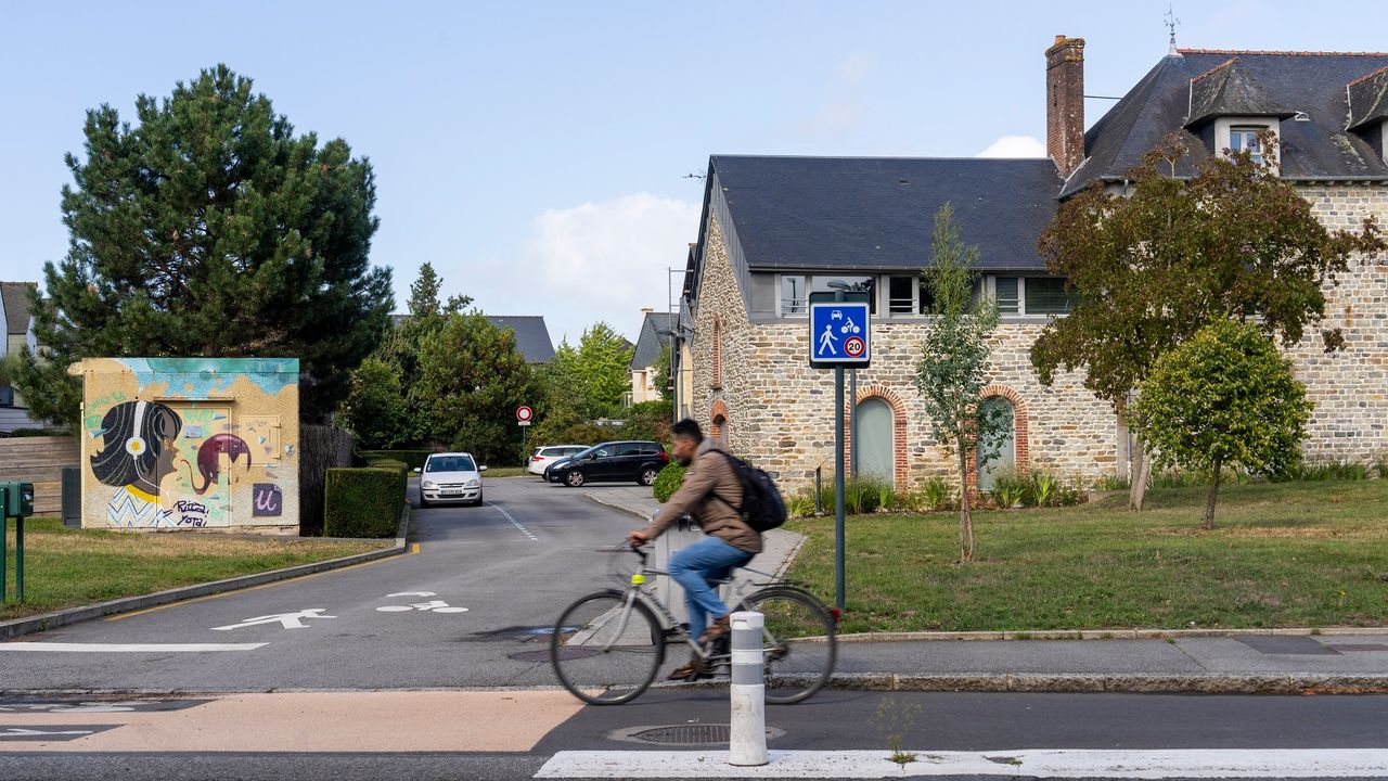 Un cycliste passe devant un panneau de signalisation.