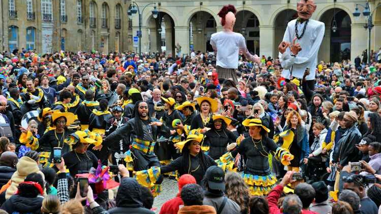 des danseurs déguisés, encerclés par une foule lors du carnaval place de la mairie à Rennes