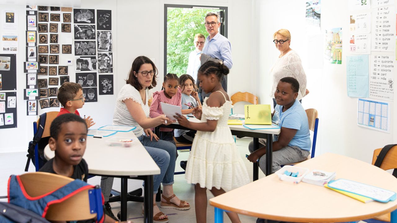 Les enfants font leurs devoirs en groupe avec l'aide d'une enseignante et en présence de la maire Nathalie Appéré.