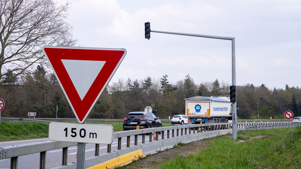 Photo de la rocade de Rennes, on aperçoit des véhicules qui circulent. En arrière plan le feu de circulation qui limite l'accès à la rocade est éteint.