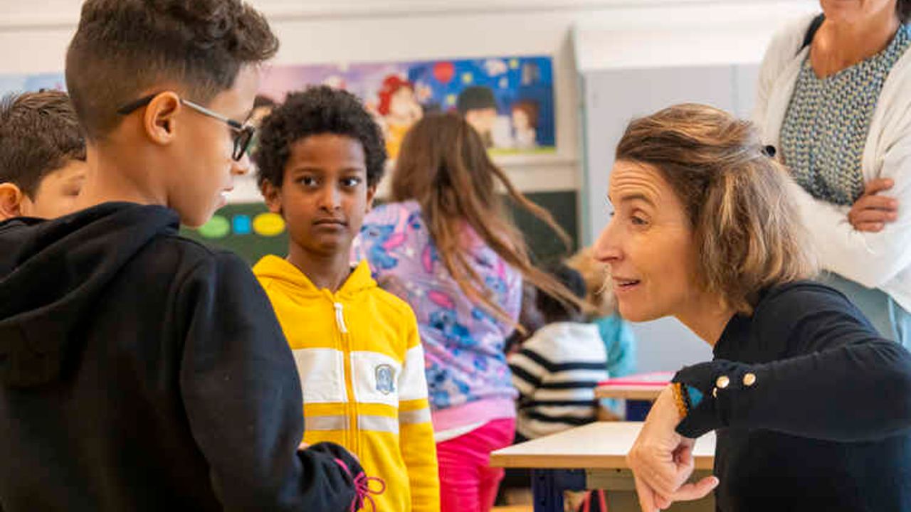 Des enfants échangent avec une enseignante en classe