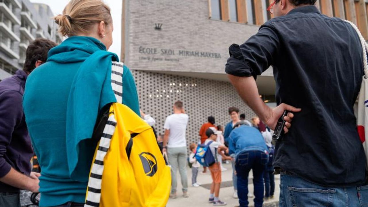 Des parents accompagnent leurs enfants pour leur rentrée scolaire devant la nouvelle école Miriam-Makeba.