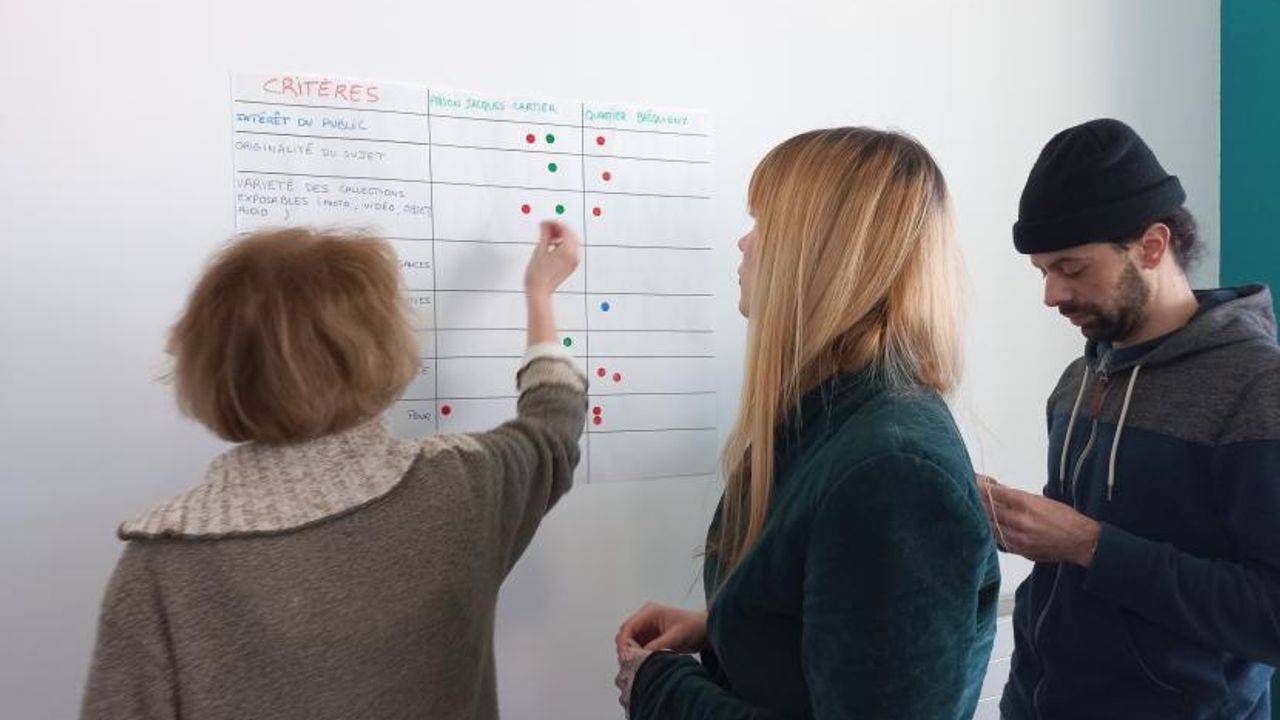 Trois personnes remplissent un tableau.