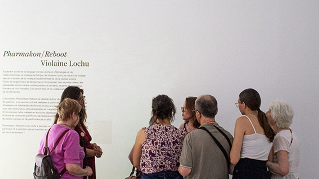 A l'entrée de l'exposition, le groupe écoute la médiatrice.