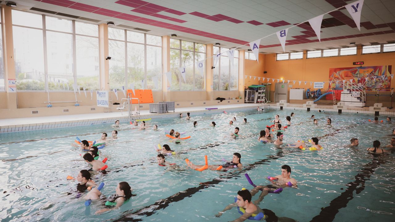 Des nageurs avec des frites sont posés dans la piscine. 
