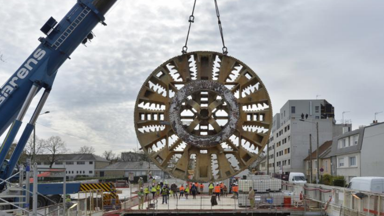 28 février 2018 : Élaine sort de terre... Le tunnelier achève son odyssée souterraine boulevard de Vitré, près de la station Joliot-Curie. Il aura creusé au total 8,6 km de tunnel profond, traversant 9 stations.