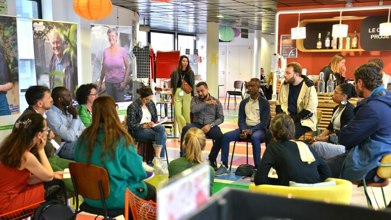 un groupe de personnes sont assises en cercle et discutent ensemble