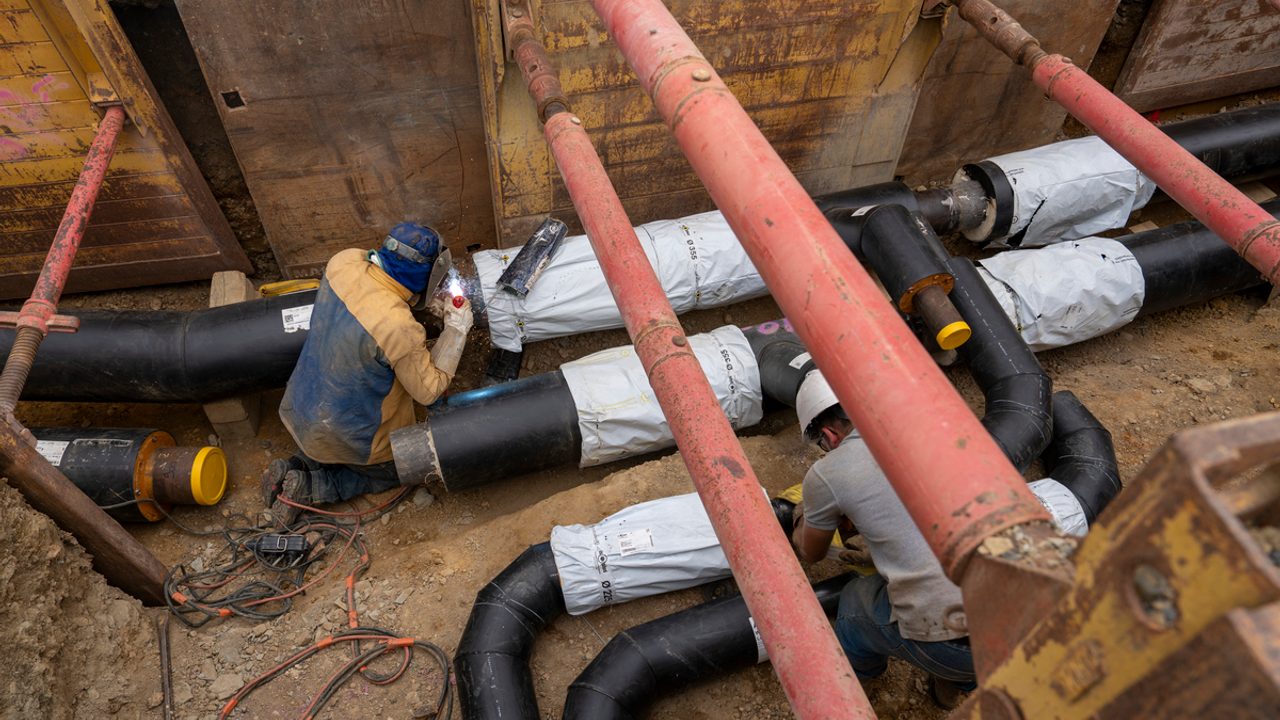 Un homme s’attèle à la construction d’un réseau de chaleur enterré.