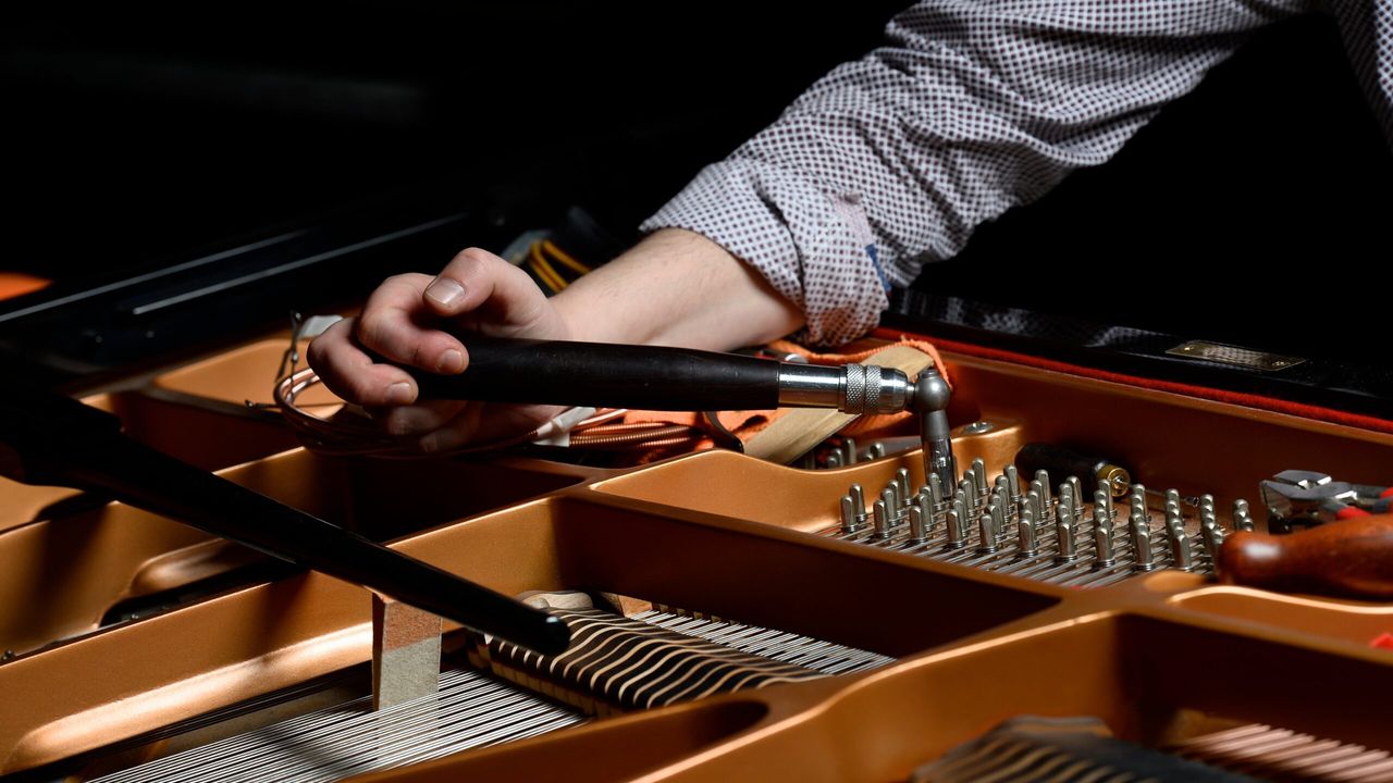 Accordeur de Desevedavy Pianos qui accorde les cordes d'un piano